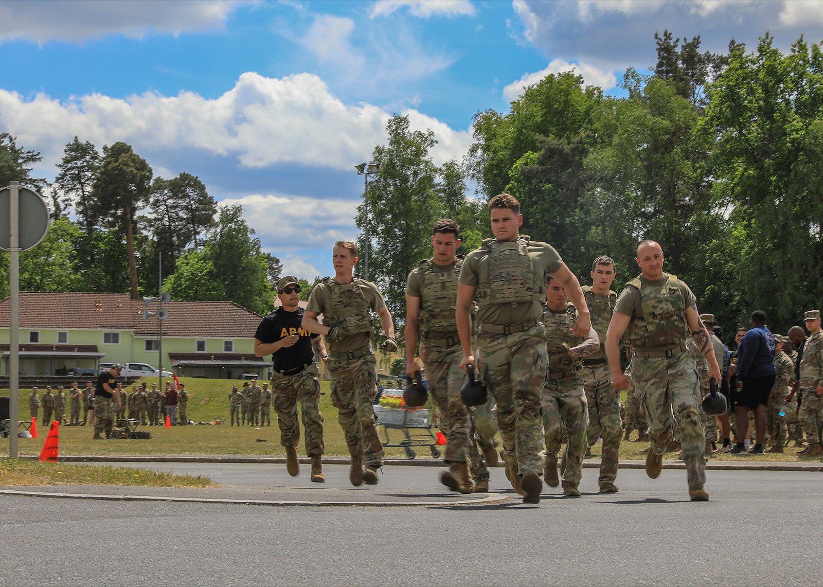 Une section de militaires en tenue de combat pendant une épreuve physique en groupe