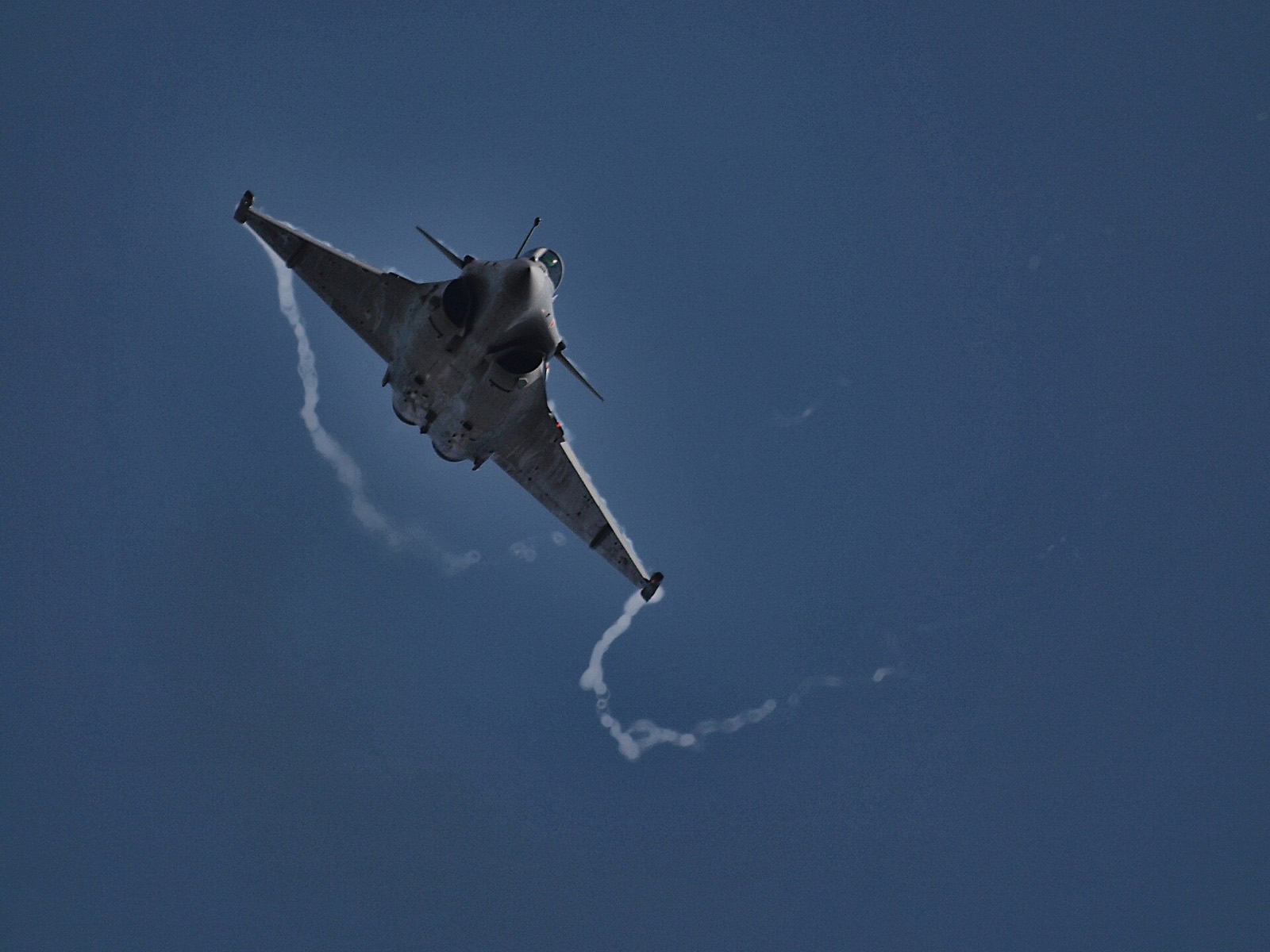 Un Rafale de l'armée de l'Air en virage serré, dans un ciel bleu