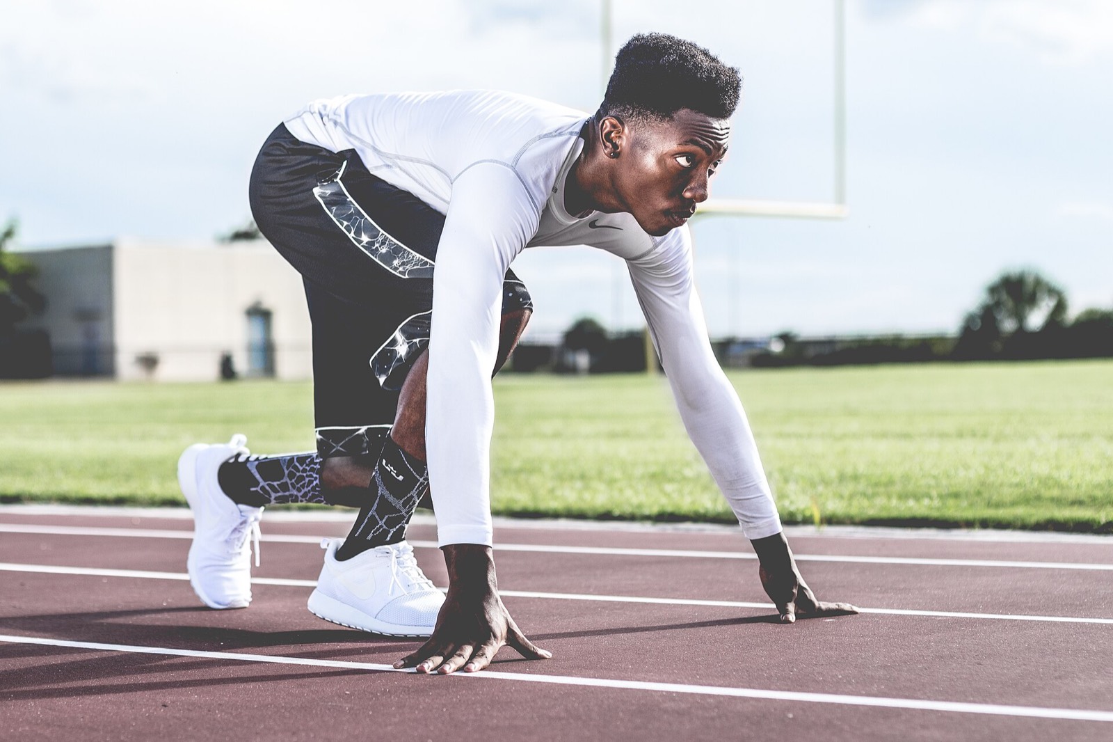 Un coureur en position de départ sur une piste d'athlétisme