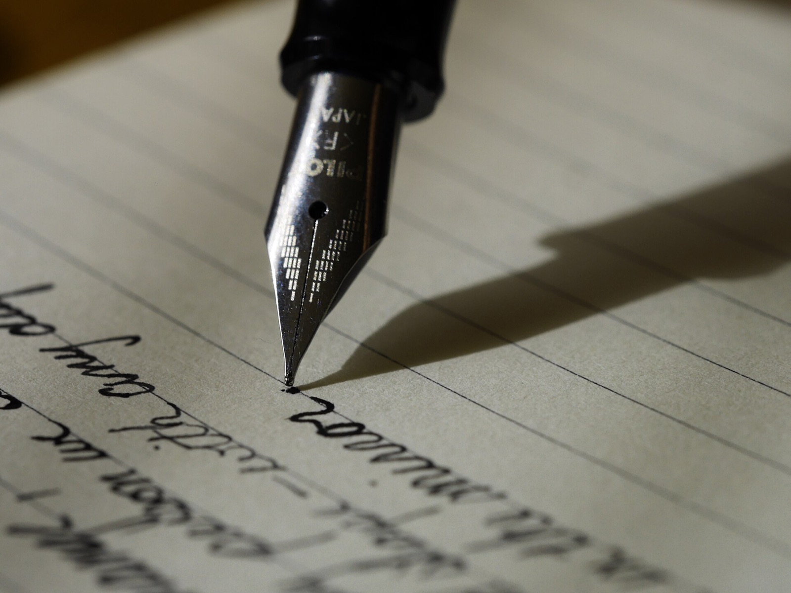 La plume d'un stylo au-dessus d'une page manuscrite