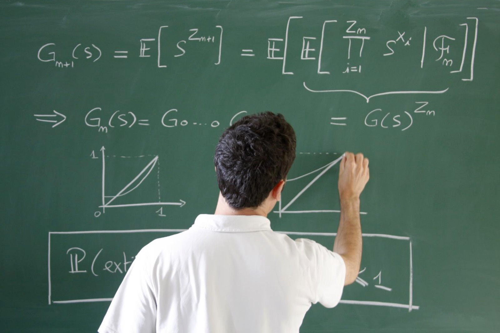 Un étudiant écrit des équations à la craie sur un tableau vert