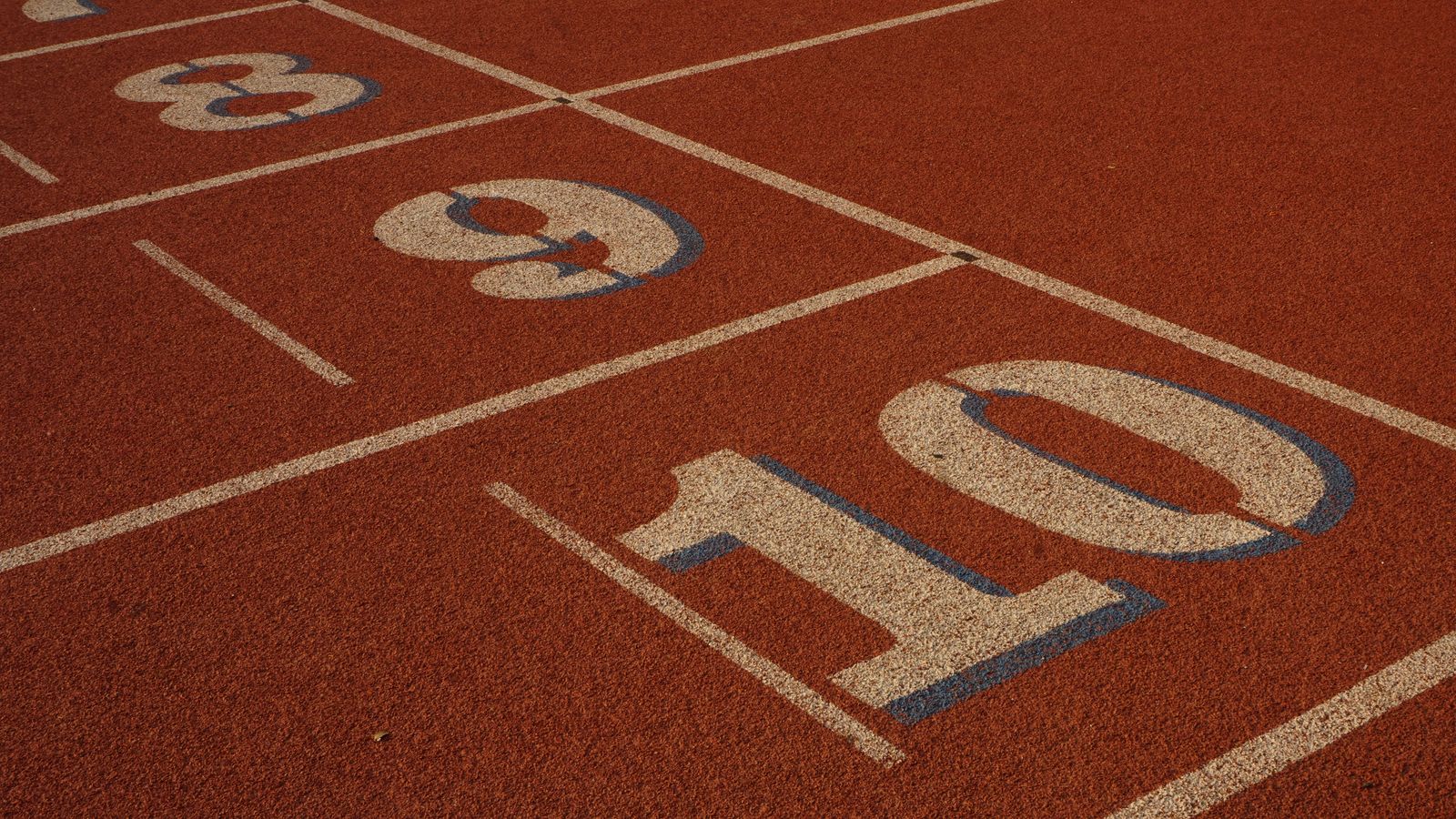 Couloirs numérotés d'une piste d'athlétisme, vus de près